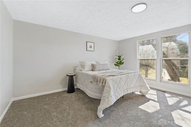 bedroom with visible vents, carpet, baseboards, and a textured ceiling