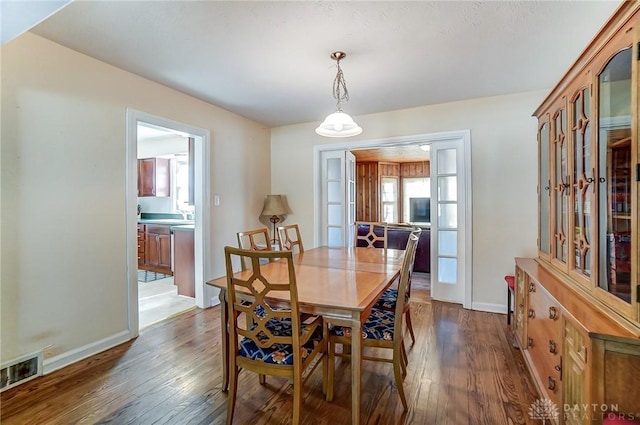 dining room with visible vents, baseboards, and wood finished floors