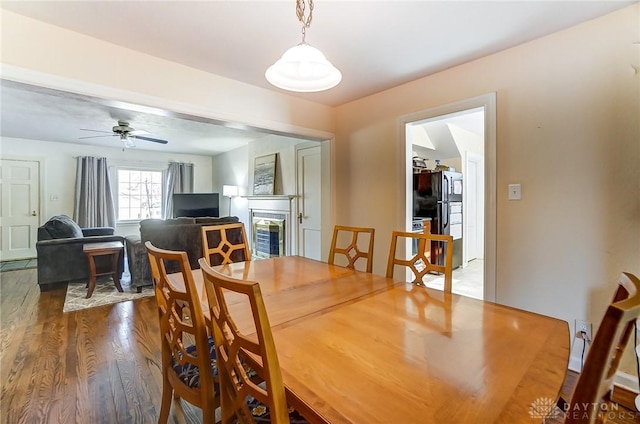 dining space with ceiling fan and wood finished floors