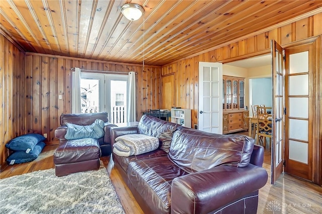 living area with wood finished floors, french doors, wood walls, and wooden ceiling