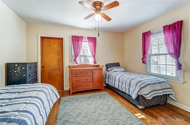 bedroom featuring baseboards, ceiling fan, and wood finished floors