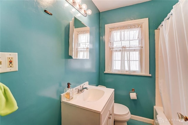 bathroom with vanity, toilet, plenty of natural light, and baseboards