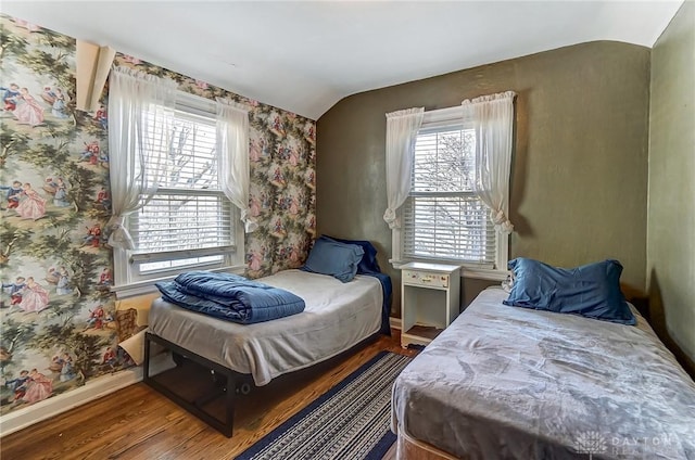 bedroom featuring baseboards, multiple windows, wood finished floors, and vaulted ceiling