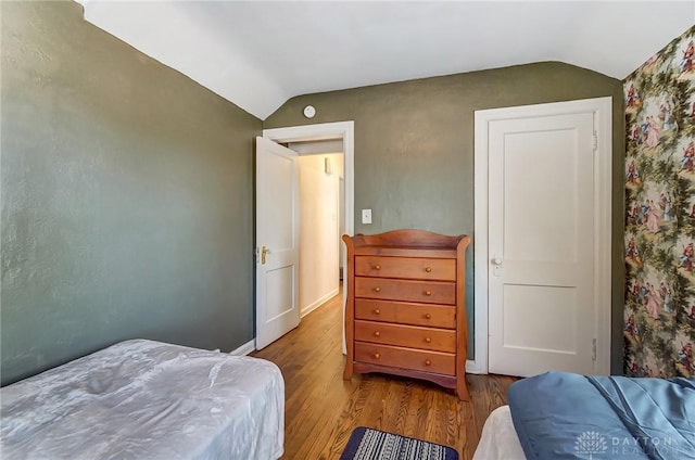 bedroom featuring wood finished floors and vaulted ceiling