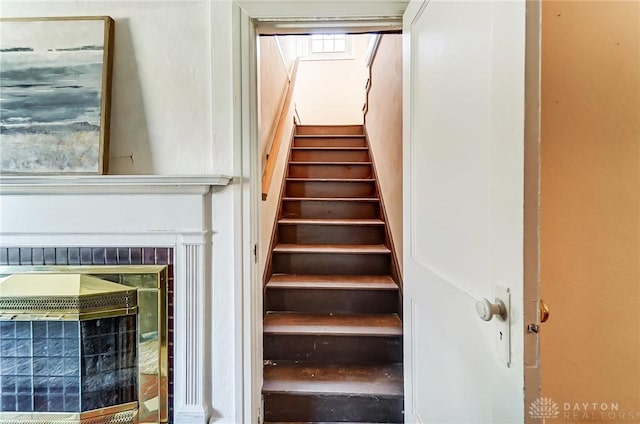 stairway with a glass covered fireplace