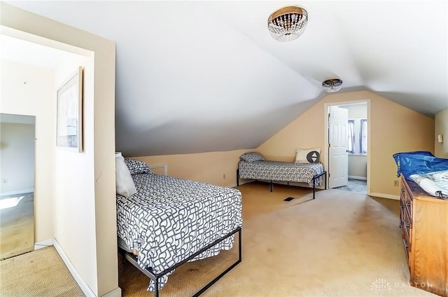 carpeted bedroom featuring baseboards and vaulted ceiling