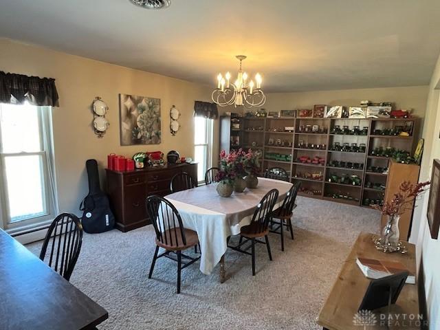 dining area with an inviting chandelier and carpet floors