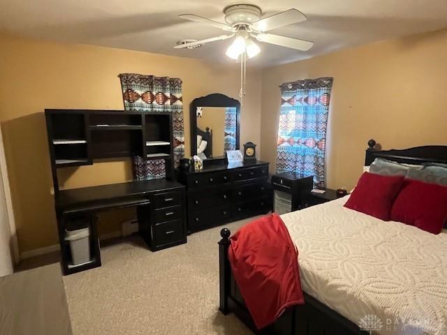 bedroom with light carpet and a ceiling fan