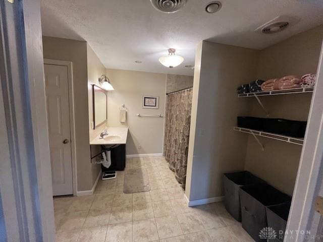 full bath featuring tile patterned flooring, visible vents, curtained shower, and baseboards