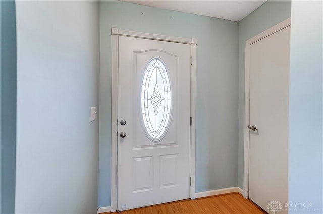 foyer with light wood finished floors and baseboards