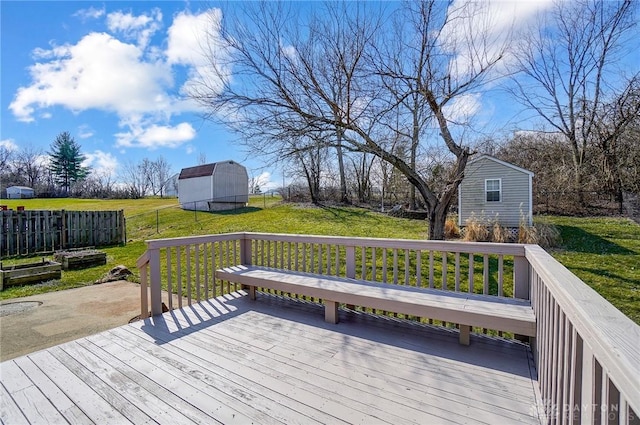 deck with a lawn, a storage shed, an outdoor structure, and fence