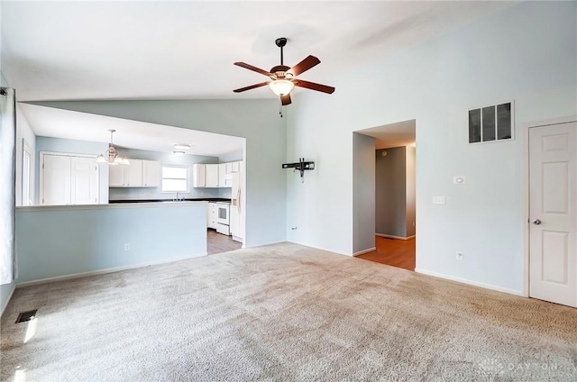 unfurnished living room with a ceiling fan, lofted ceiling, carpet, and visible vents