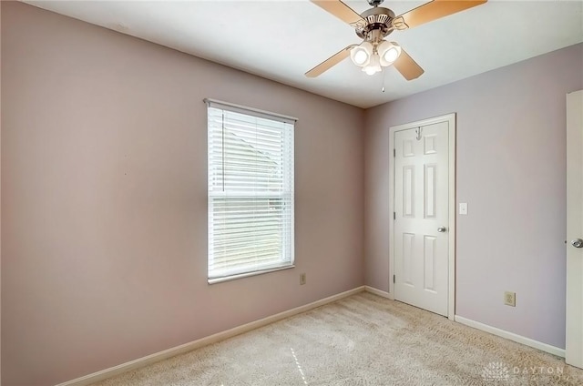 unfurnished bedroom with a ceiling fan, light colored carpet, and baseboards