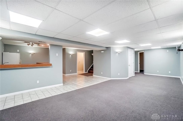 interior space featuring tile patterned floors, stairway, a paneled ceiling, and baseboards