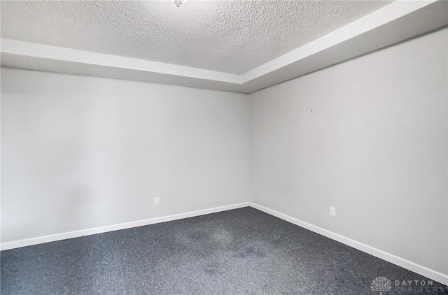 unfurnished room featuring baseboards and a textured ceiling