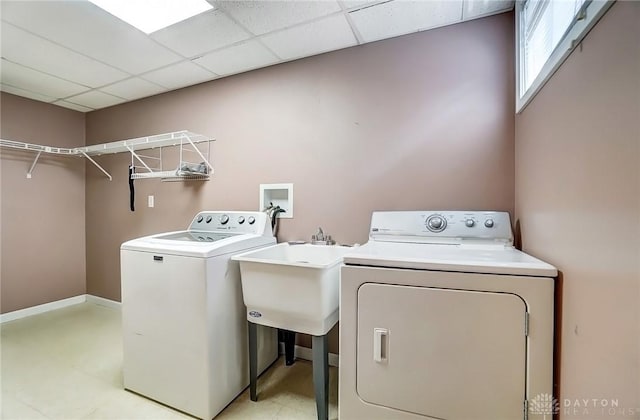 laundry area with baseboards, separate washer and dryer, and laundry area