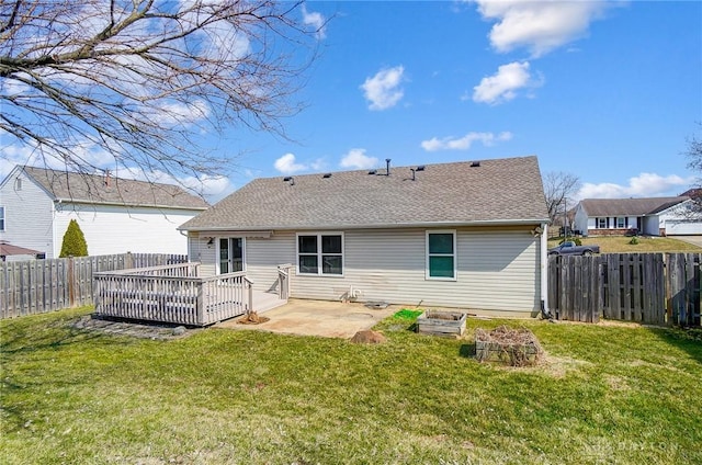 rear view of house with a shingled roof, a wooden deck, a lawn, a fenced backyard, and a patio