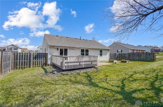 rear view of property with a fenced backyard, a deck, and a yard