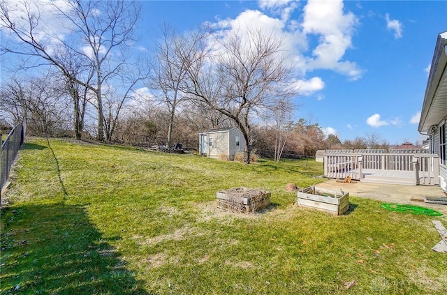 view of yard featuring a storage unit, a fenced backyard, a vegetable garden, and an outdoor structure