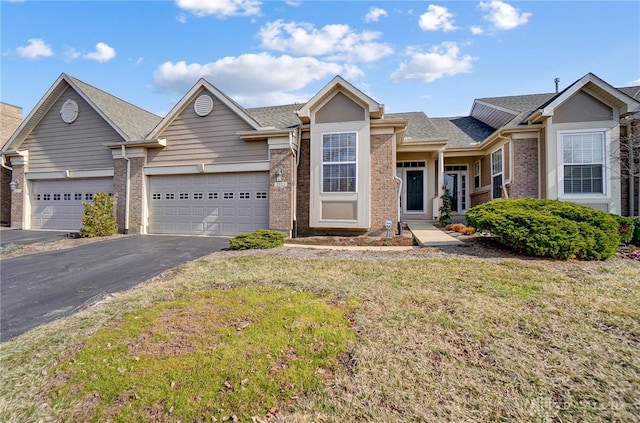 single story home with a front lawn, aphalt driveway, a shingled roof, a garage, and brick siding