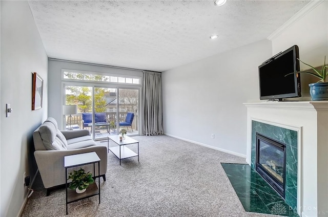 carpeted living room with ornamental molding, a textured ceiling, a high end fireplace, recessed lighting, and baseboards