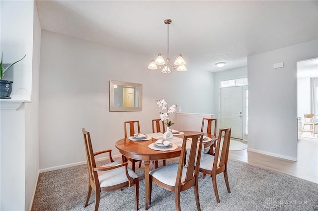 dining space featuring baseboards and a chandelier