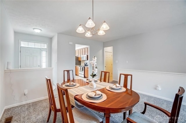 dining space featuring a notable chandelier, light colored carpet, visible vents, and baseboards