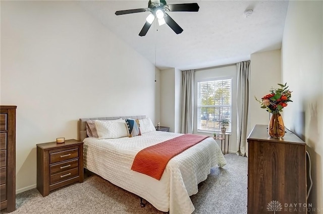 bedroom with vaulted ceiling, light colored carpet, baseboards, and ceiling fan