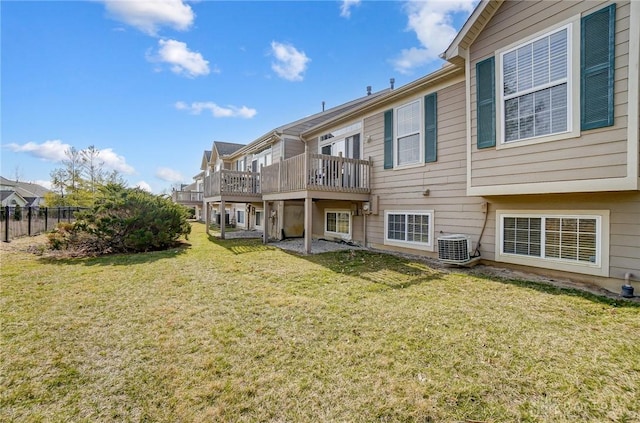 rear view of house with central AC unit, a yard, fence, and a wooden deck