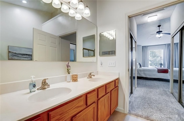 ensuite bathroom with double vanity, ensuite bathroom, ceiling fan, and a sink