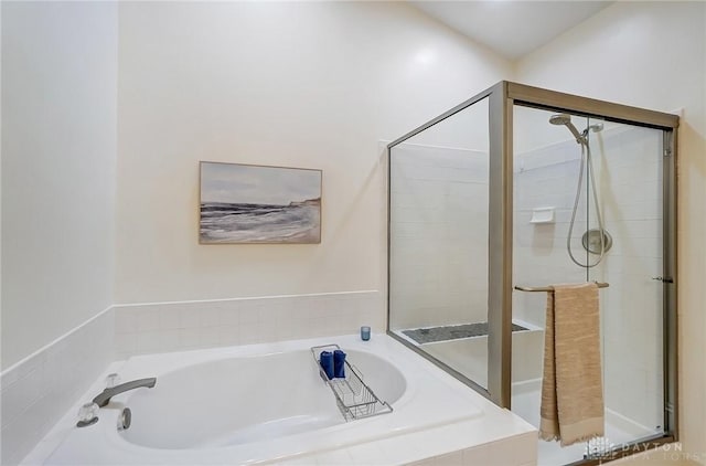 bathroom featuring a garden tub and a shower stall