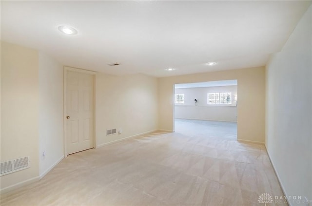 empty room featuring recessed lighting, visible vents, baseboards, and light colored carpet