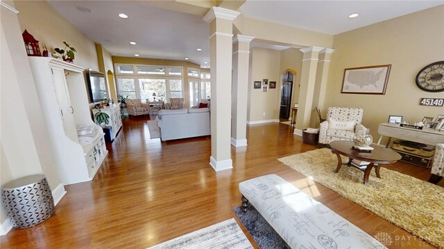 living area with recessed lighting, baseboards, wood finished floors, and ornate columns