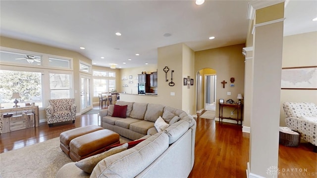 living room with baseboards, recessed lighting, wood finished floors, arched walkways, and a ceiling fan