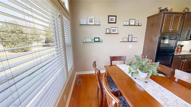 dining room with visible vents, wood finished floors, and baseboards