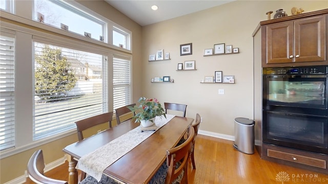 dining space featuring baseboards and light wood finished floors