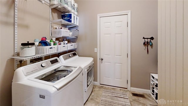 laundry room featuring baseboards, separate washer and dryer, and laundry area