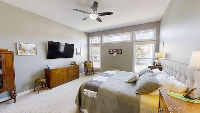 bedroom featuring a ceiling fan, light colored carpet, and baseboards