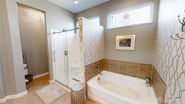 full bathroom with a bath, tile patterned flooring, a stall shower, and baseboards