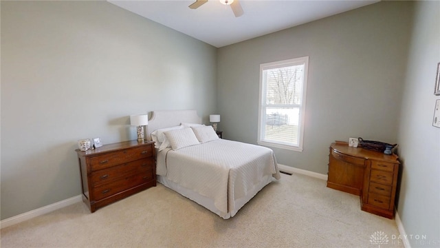 bedroom featuring light colored carpet, a ceiling fan, and baseboards