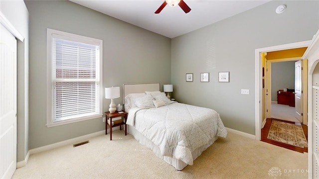 carpeted bedroom with visible vents, baseboards, and a ceiling fan