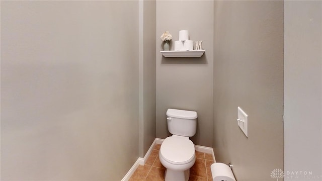 bathroom featuring tile patterned flooring, toilet, and baseboards