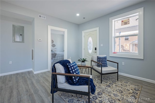 living area featuring visible vents, electric panel, wood finished floors, recessed lighting, and baseboards