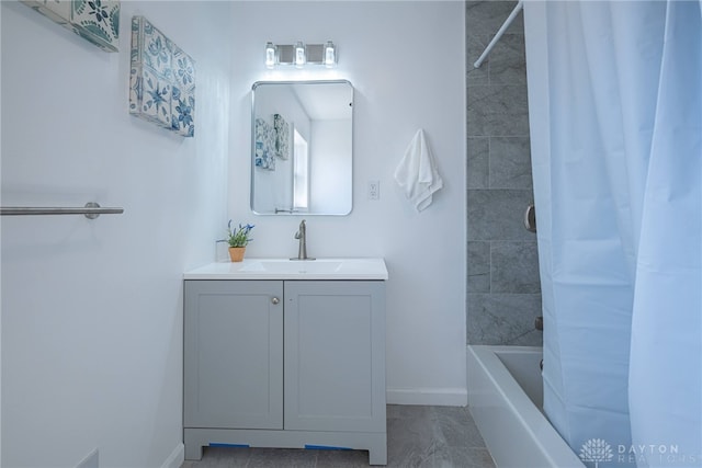 full bath with baseboards, shower / bath combo, and vanity