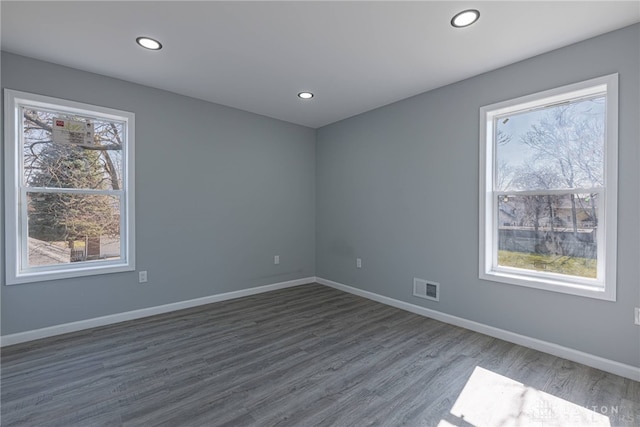 spare room with recessed lighting, baseboards, visible vents, and dark wood-style flooring