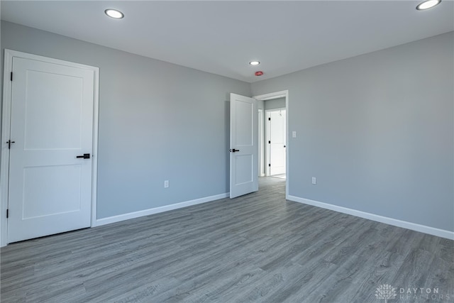 empty room with recessed lighting, baseboards, and wood finished floors