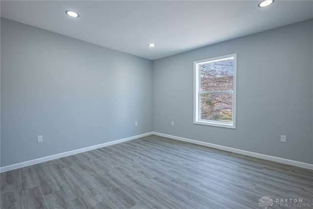 empty room featuring recessed lighting, baseboards, and wood finished floors