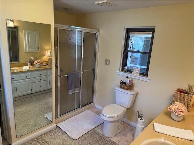 full bathroom with vanity, toilet, baseboards, and a stall shower