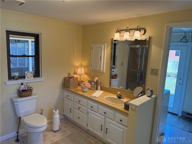 bathroom featuring an enclosed shower, baseboards, toilet, and vanity