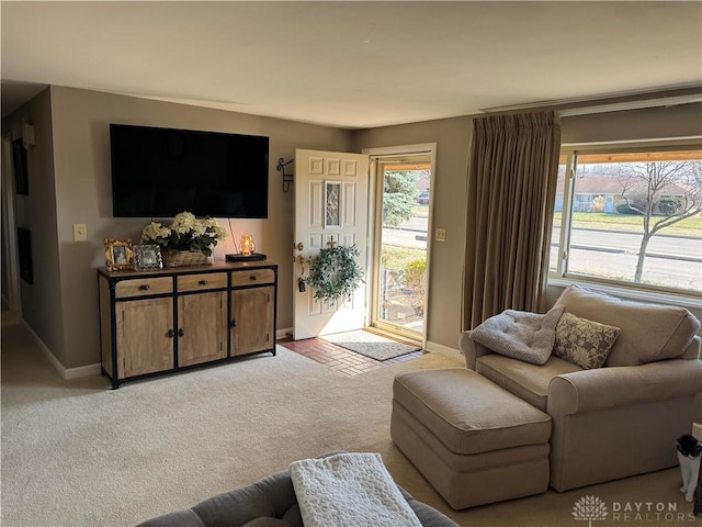 living area with light carpet and baseboards